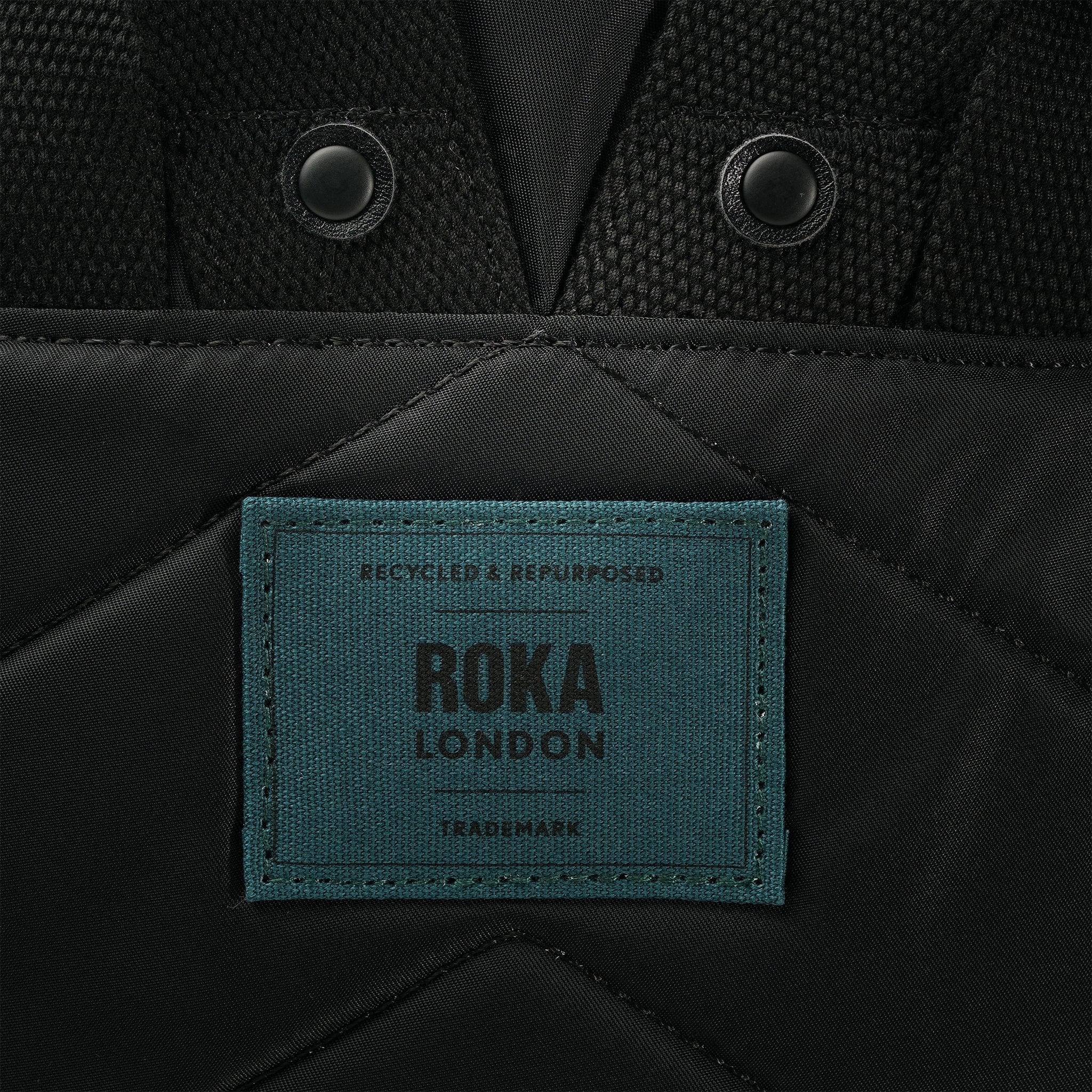 Roka Canfield Medium Teal Recycled Nylon Backpack, brand label detail.