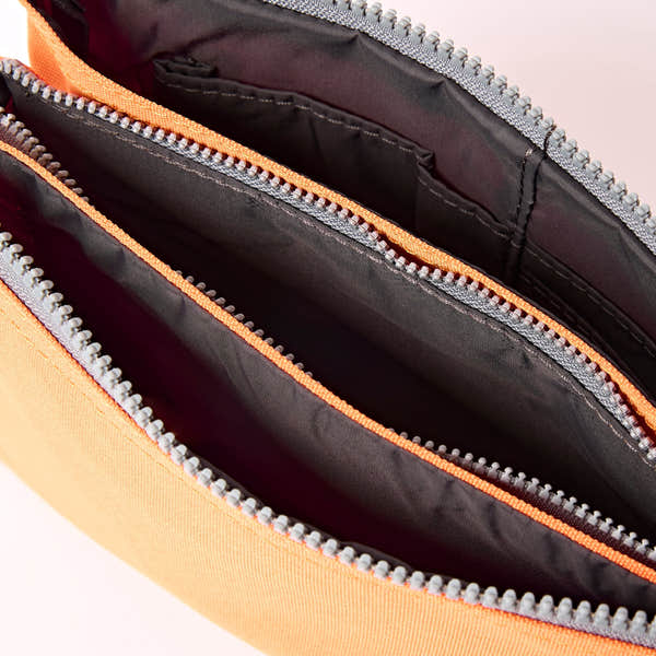 Roka Carnaby XL Jaffa Orange Recycled Canvas Crossbody Bag, side view.