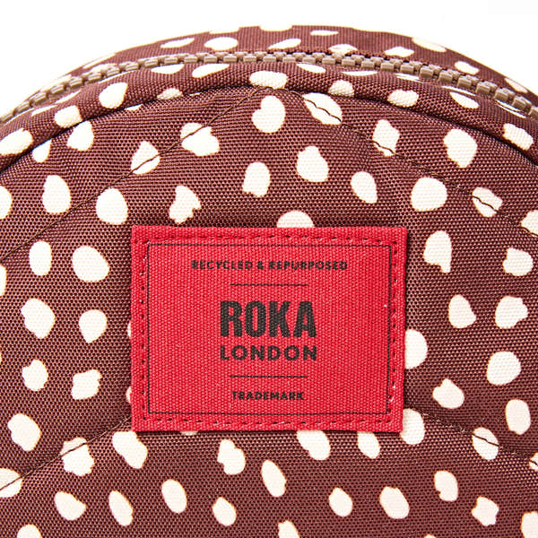 Roka Paddington Brown Dot Recycled Canvas Crossbody Bag, brand label detail.