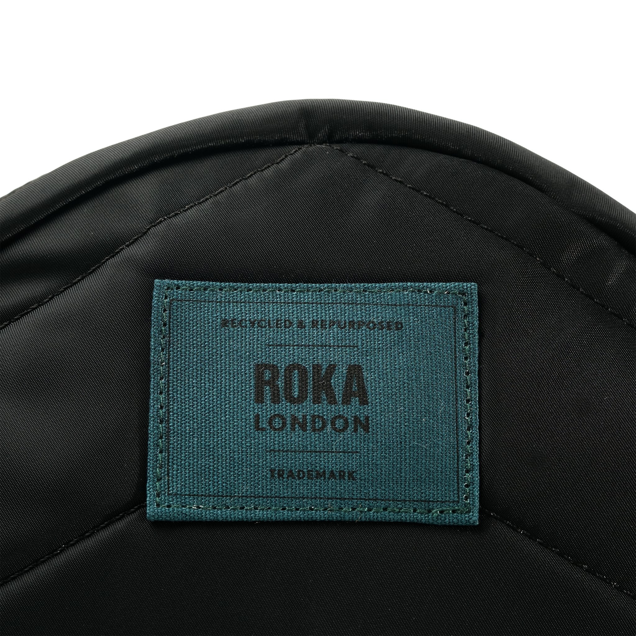 Roka Paddington Teal Recycled Nylon Crossbody Bag, brand label detail.
