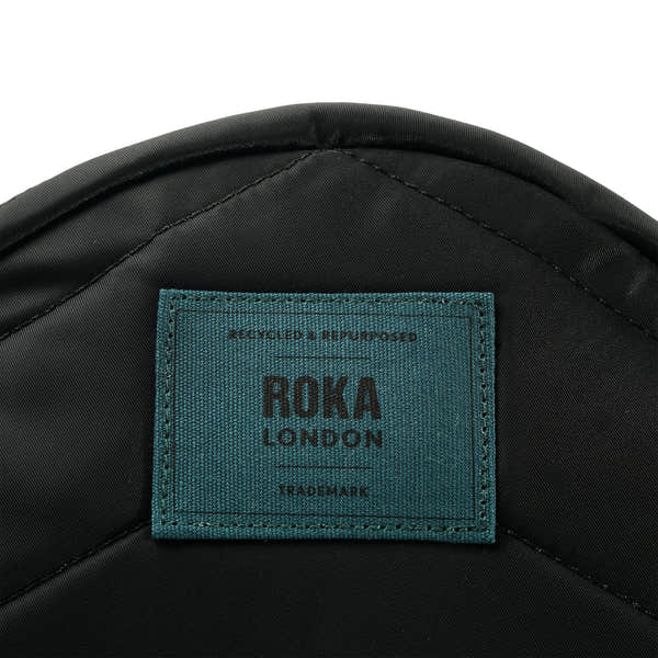 Roka Paddington Teal Recycled Nylon Crossbody Bag, brand label detail.