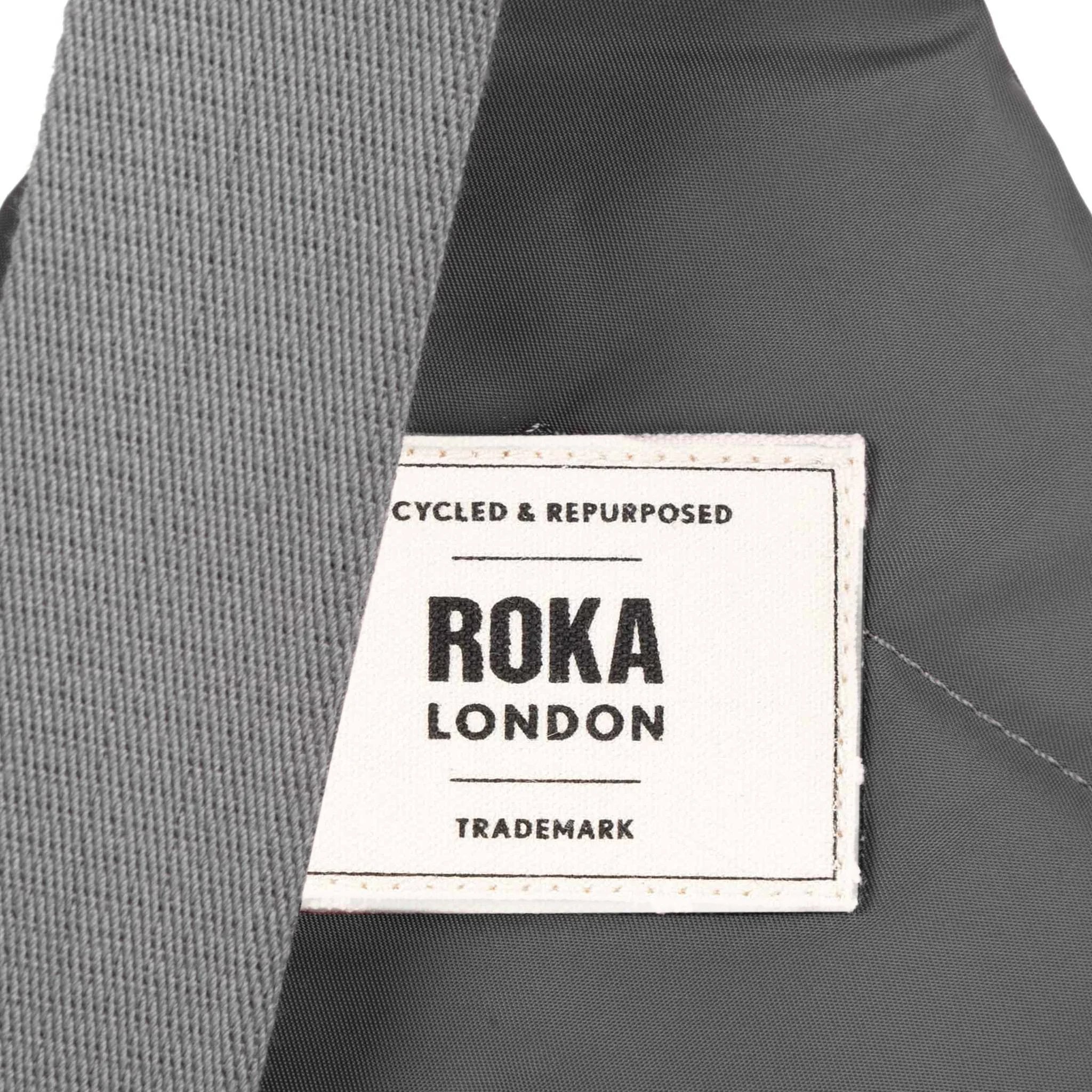 Roka Willesden Graphite Recycled Nylon Sling Bag, brand label detail.