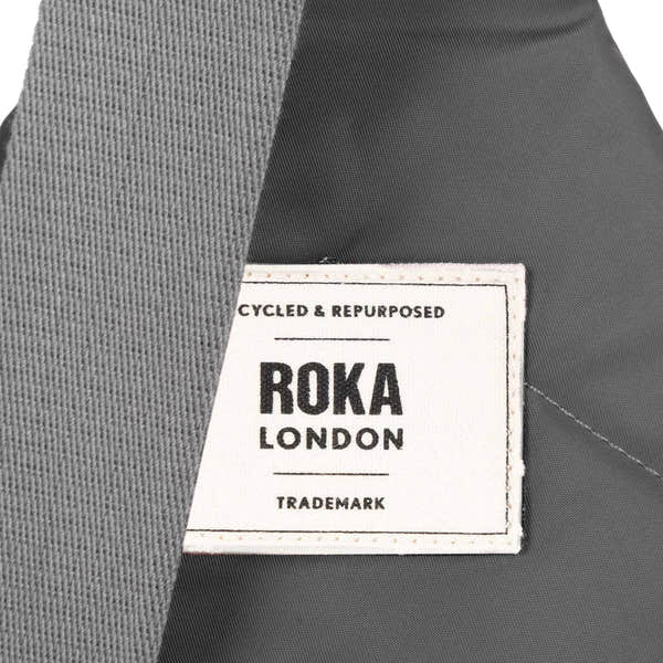 Roka Willesden Graphite Recycled Nylon Sling Bag, brand label detail.