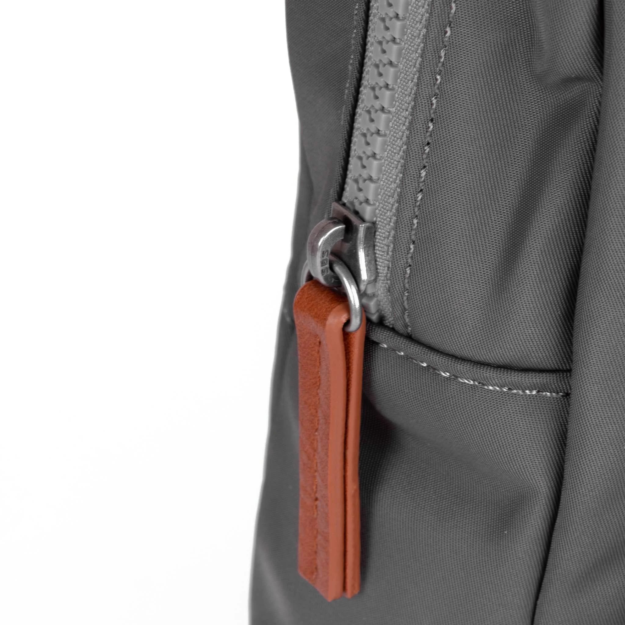Roka Willesden Graphite Recycled Nylon Sling Bag, zip detail.