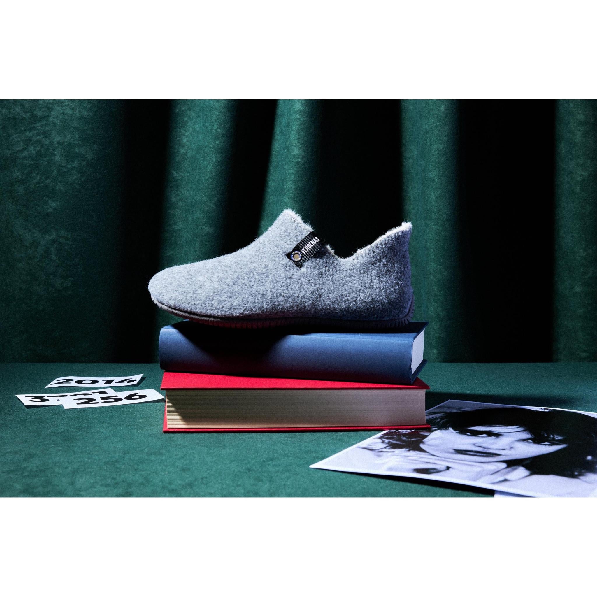 Verbenas Yoi Picos Pet Tone women's charcoal grey slippers displayed on stacked books.