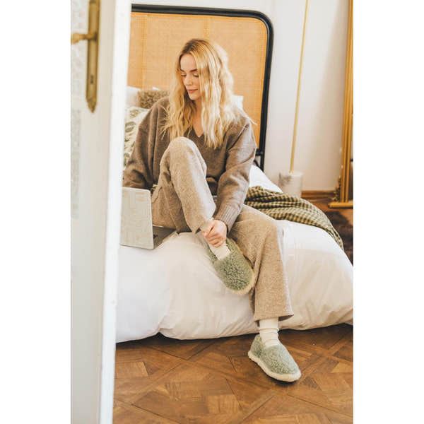 Yoko Full unisex Green wool slippers worn with loungewear in a bedroom, lifestyle view.